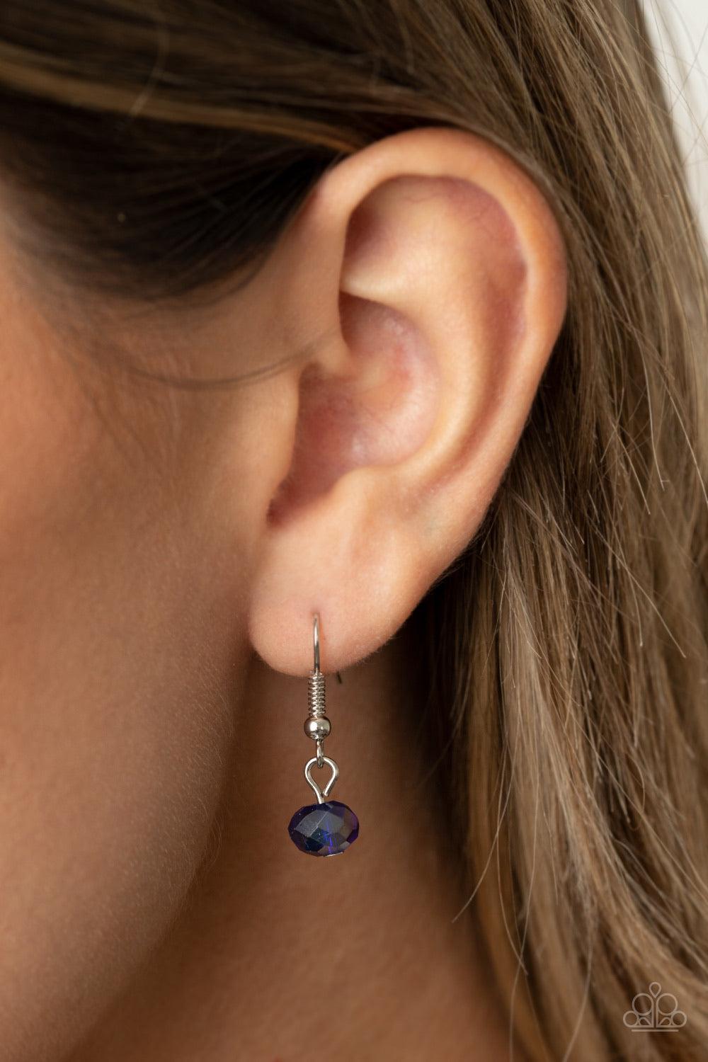 Paparazzi Accessories Fashionista Week - Blue Featuring an iridescent shimmer, an oval blue crystal-like bead swings from the bottom of a matching crystal-beaded chain, creating an elegantly extended pendant below the collar. Features an adjustable clasp