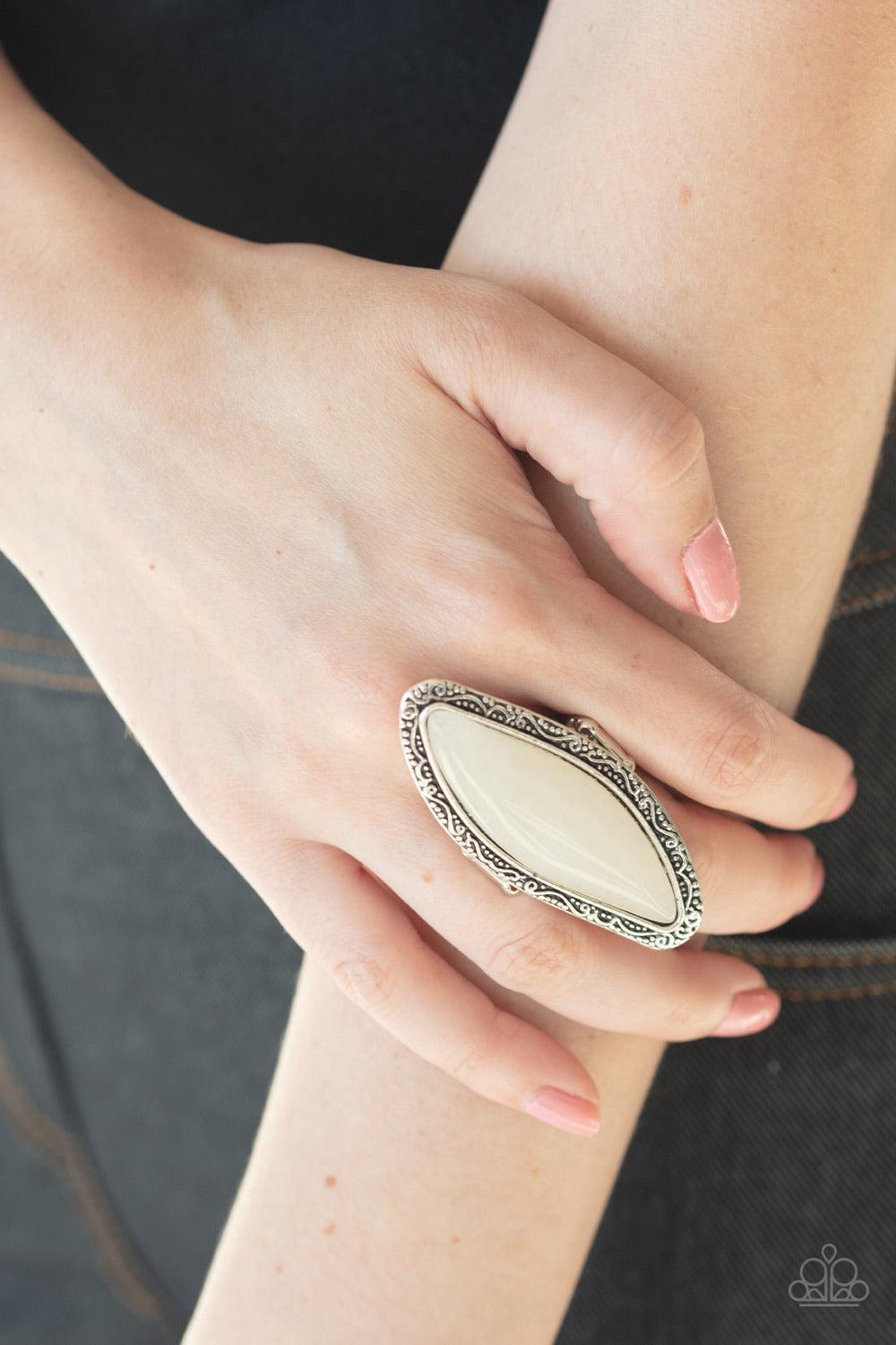 Paparazzi Accessories Mineral Mine - White An oblong white stone is pressed into a shimmery silver frame embossed and studded in tactile filigree, creating a dramatic stone display atop the finger. Features a stretchy band for a flexible Jewelry