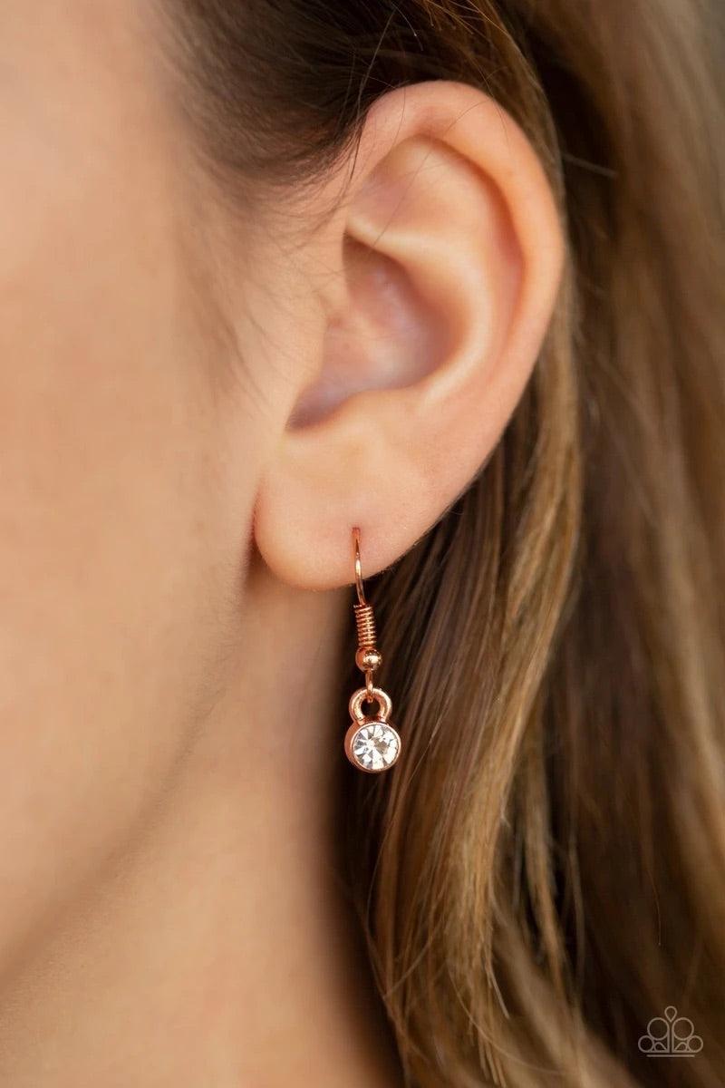 Paparazzi Accessories Queen Bling - Copper Featuring a regal emerald style cut, an oversized gem swings from the bottom of dramatic white rhinestone encrusted shiny copper fittings for a glamorous look. Features an adjustable clasp closure. Sold as one in