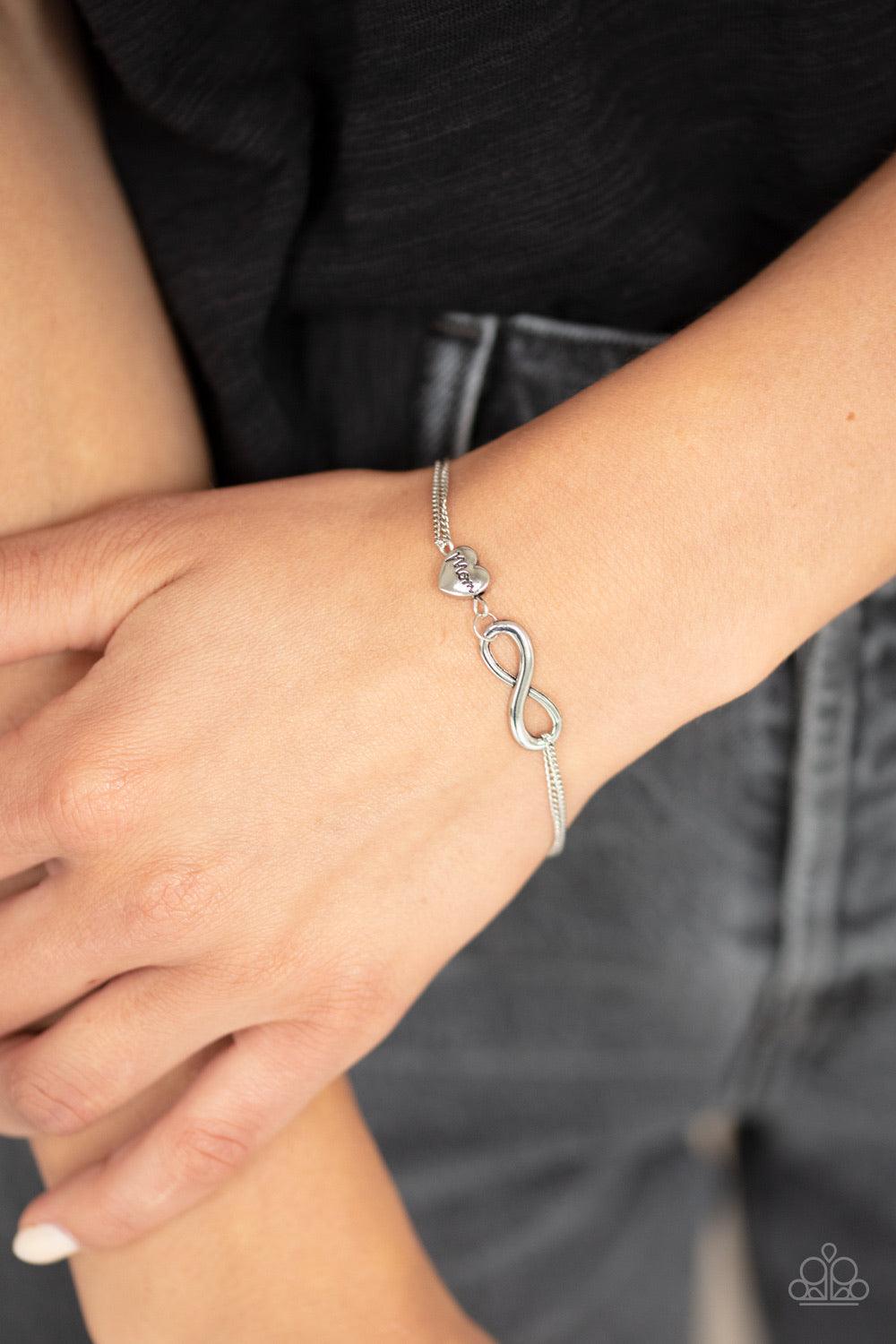 Paparazzi Accessories Purest Love - Silver A glistening silver infinity and silver heart stamped in the word, "Mom", delicately link across the wrist for a timeless look. Features an adjustable clasp closure. Jewelry