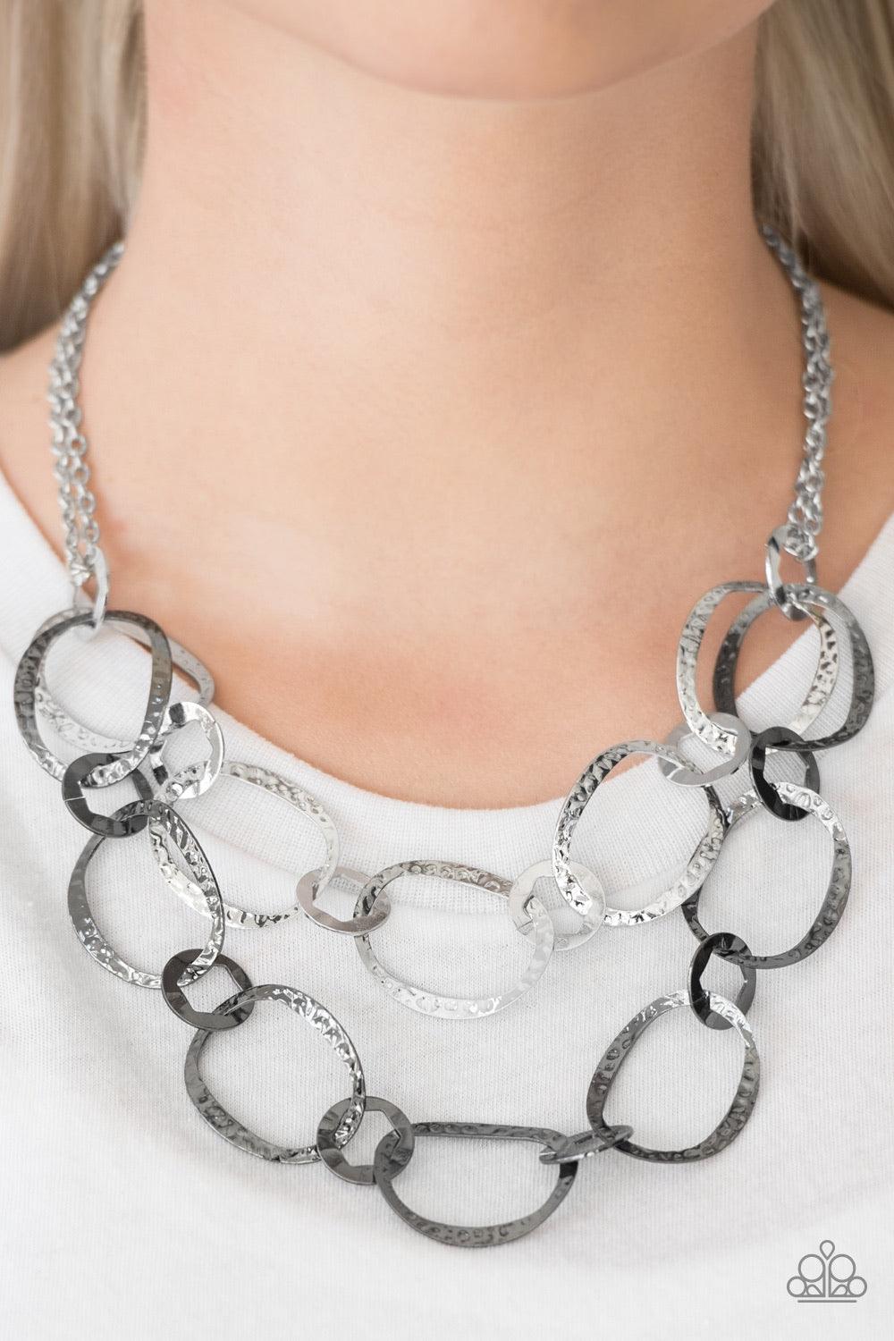 Paparazzi Accessories Circus Chic - Multi Featuring hexagonal centers, one strand of dainty silver and one strand of gunmetal rings link together into two rows of hammered frames. The layered rows drape just below the collar for a refined look. Features a