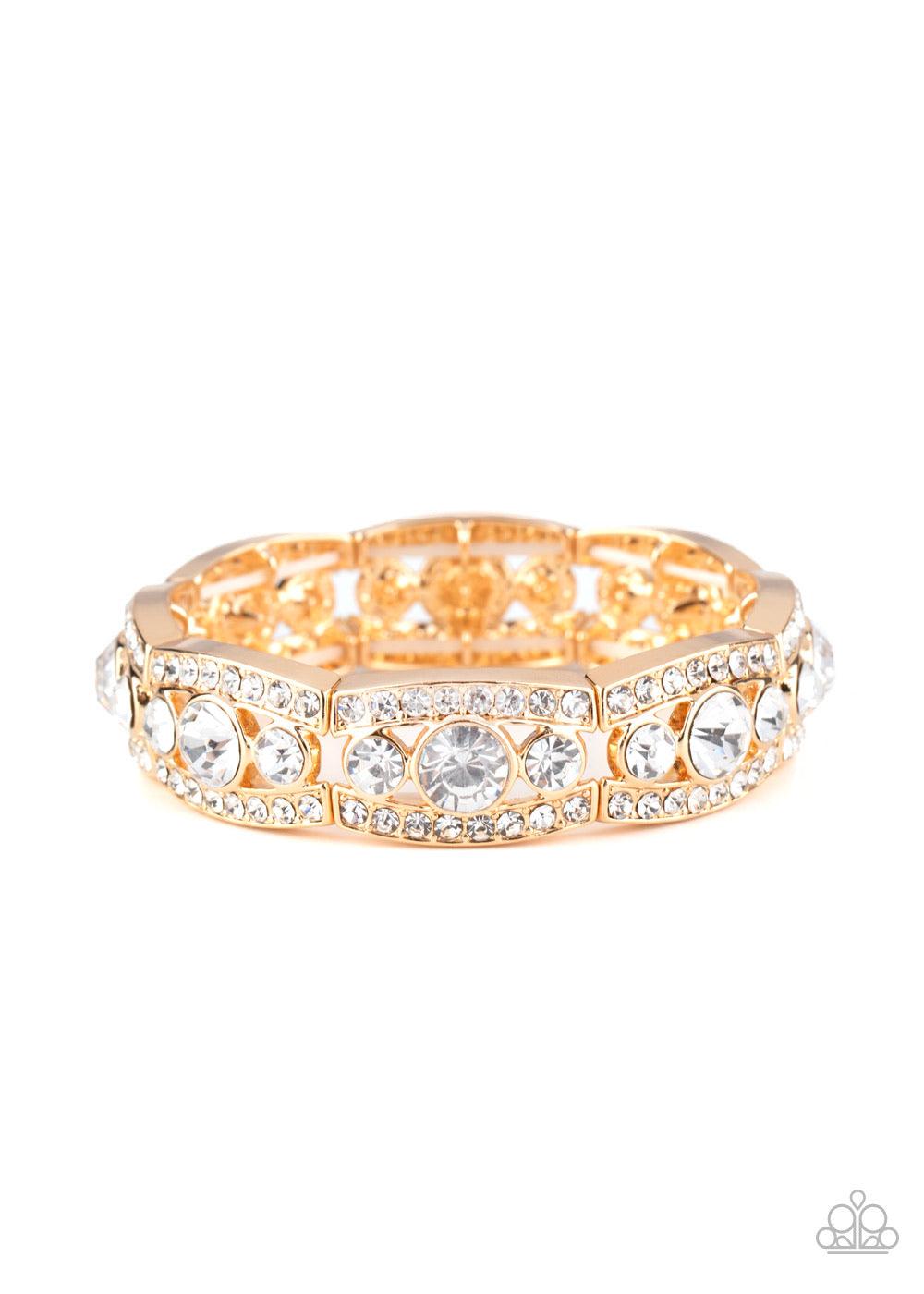 Paparazzi Accessories Easy On The ICE - Gold Rhinestone encrusted gold bars flank a dazzling trio of oversized white rhinestones, coalescing into a glittery frame. The sparkly frames are threaded along stretchy bands around the wrist, creating an irresist