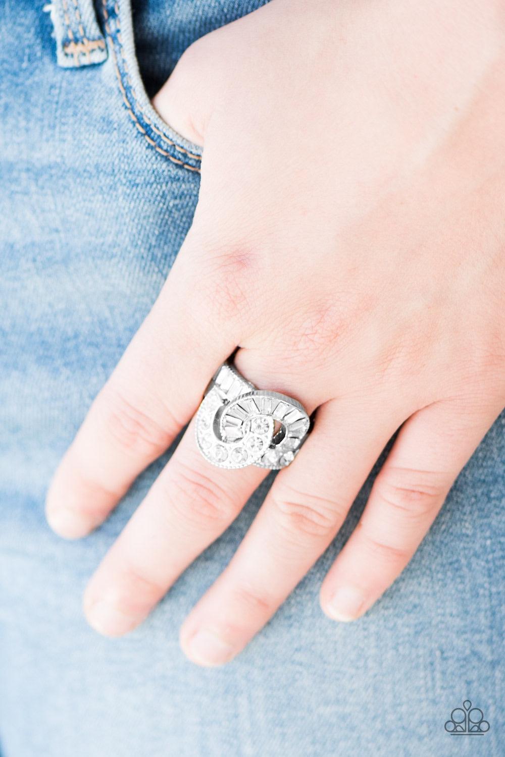 Paparazzi Accessories The Victor - White Featuring classic round and emerald style cuts, glittery white rhinestones are sprinkled along interwoven silver ribbons for the ultimate sparkle. Features a stretchy band for a flexible fit. Jewelry
