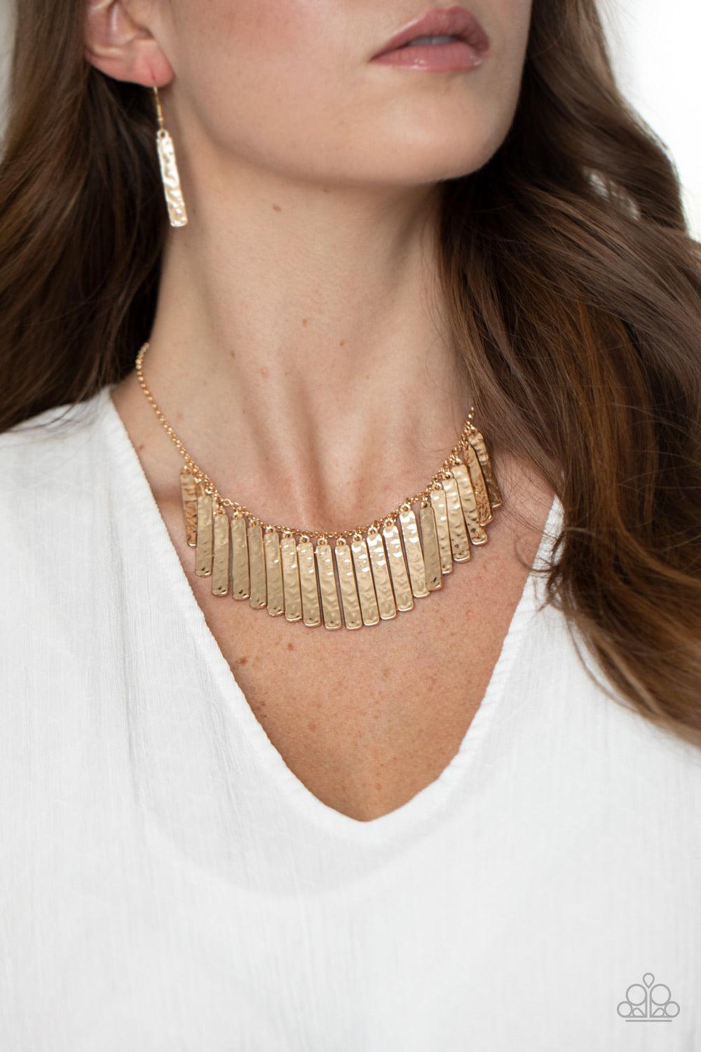 Paparazzi Accessories Metallic Muse - Gold Hammered in blinding detail, golden rectangular plates swing from the bottom of a classic gold chain, creating an edgy metallic fringe below the collar. Features an adjustable clasp closure. Sold as one individua