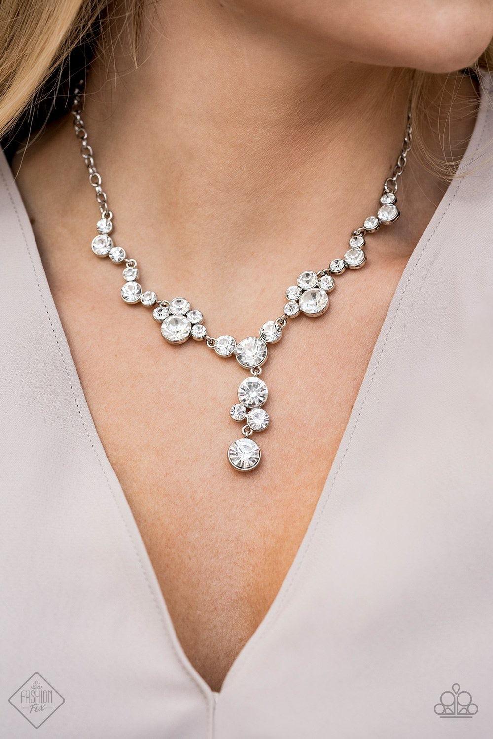 Paparazzi Accessories Inner Light - White A collection of glassy white rhinestone encrusted frames link below the collar in a timeless fashion. A matching rhinestone encrusted frame and oversized white gem dangle from the bottom, creating a glamorous exte