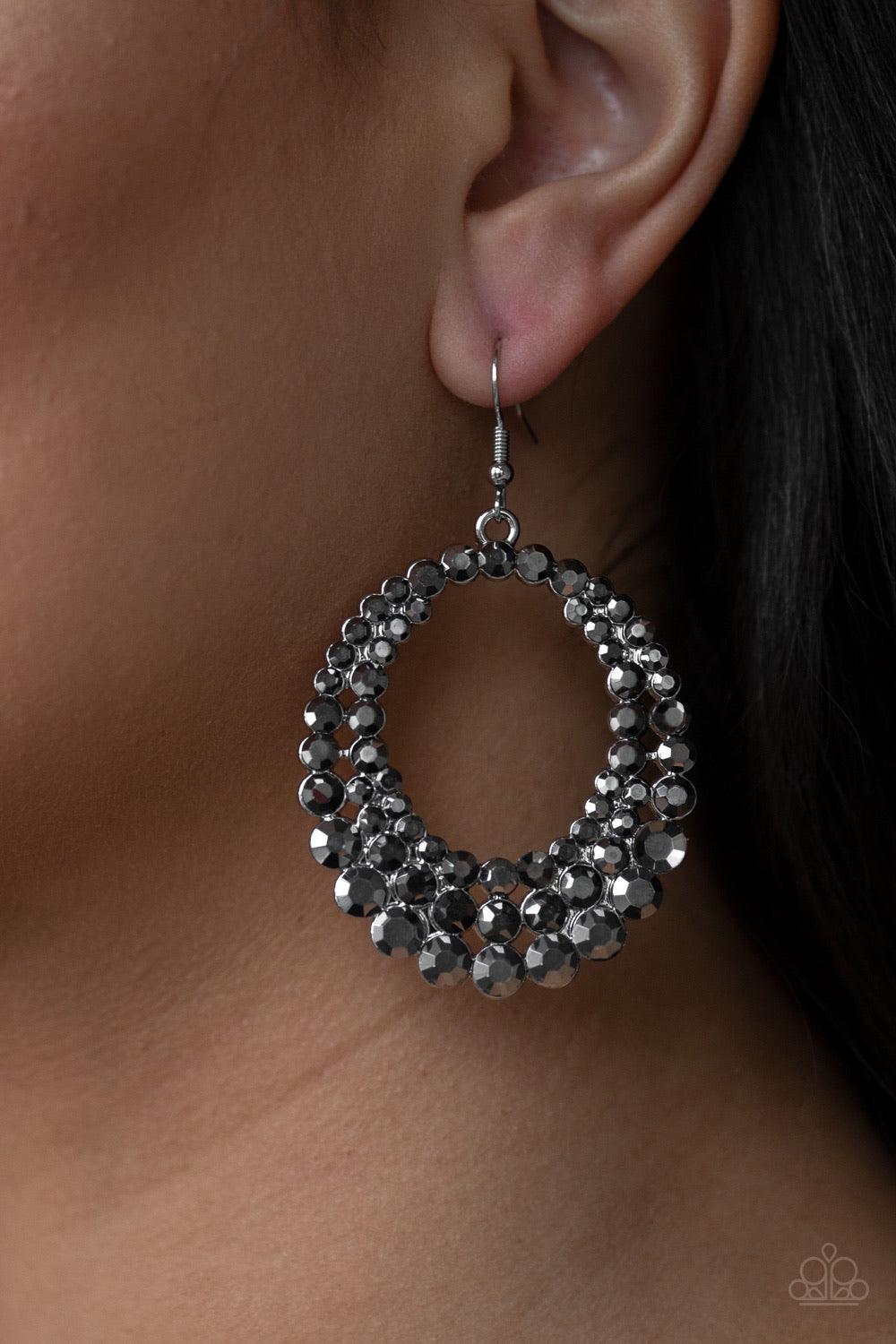 Paparazzi Accessories Universal Shimmer ~Silver Rings of glittery hematite rhinestones collect into a blinding frame in a dramatically glamorous fashion. Earring attaches to a standard fishhook fitting.