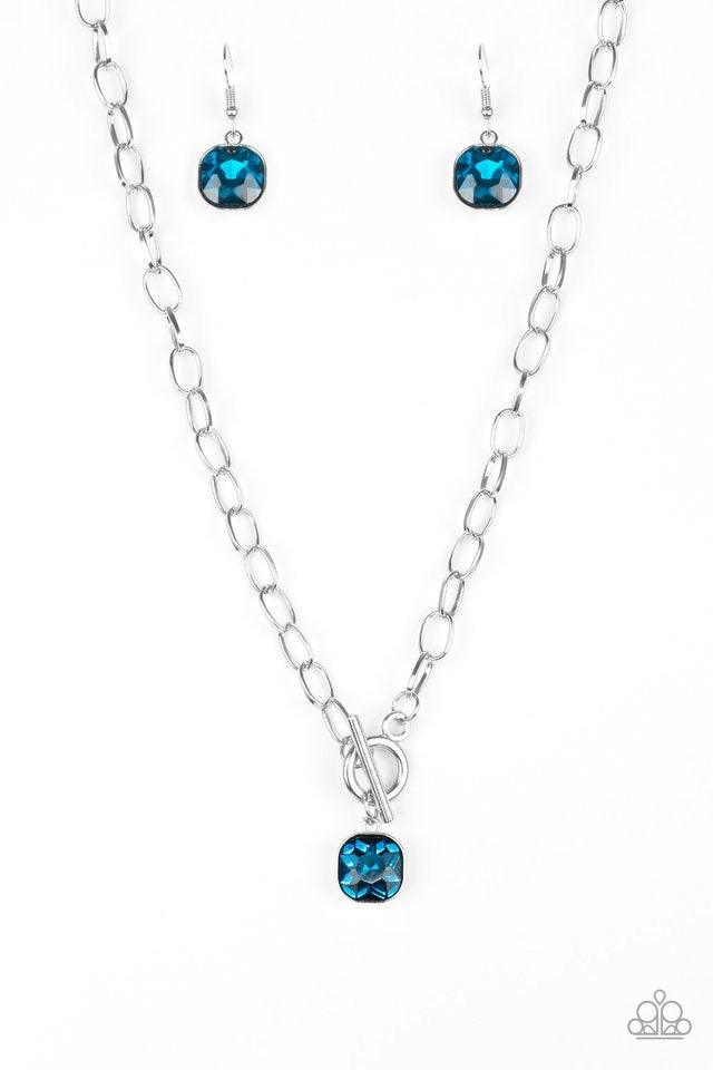 Paparazzi Accessories Dynamite Dazzle - Blue Pressed into a sleek silver frame, a dramatic blue gem swings from the bottom of a glistening silver chain below the collar for a chic look. Features a toggle closure. Jewelry