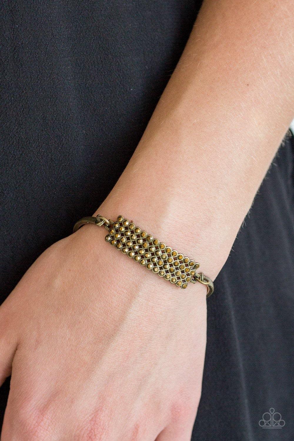 Paparazzi Accessories Top-Class Class - Brass Row after row of glittery aurum rhinestones stack into a gorgeous rectangular pendant. Attached to two arcing brass bars, the sparkling pendant sits atop the wrist for an undeniably glamorous look. Features an