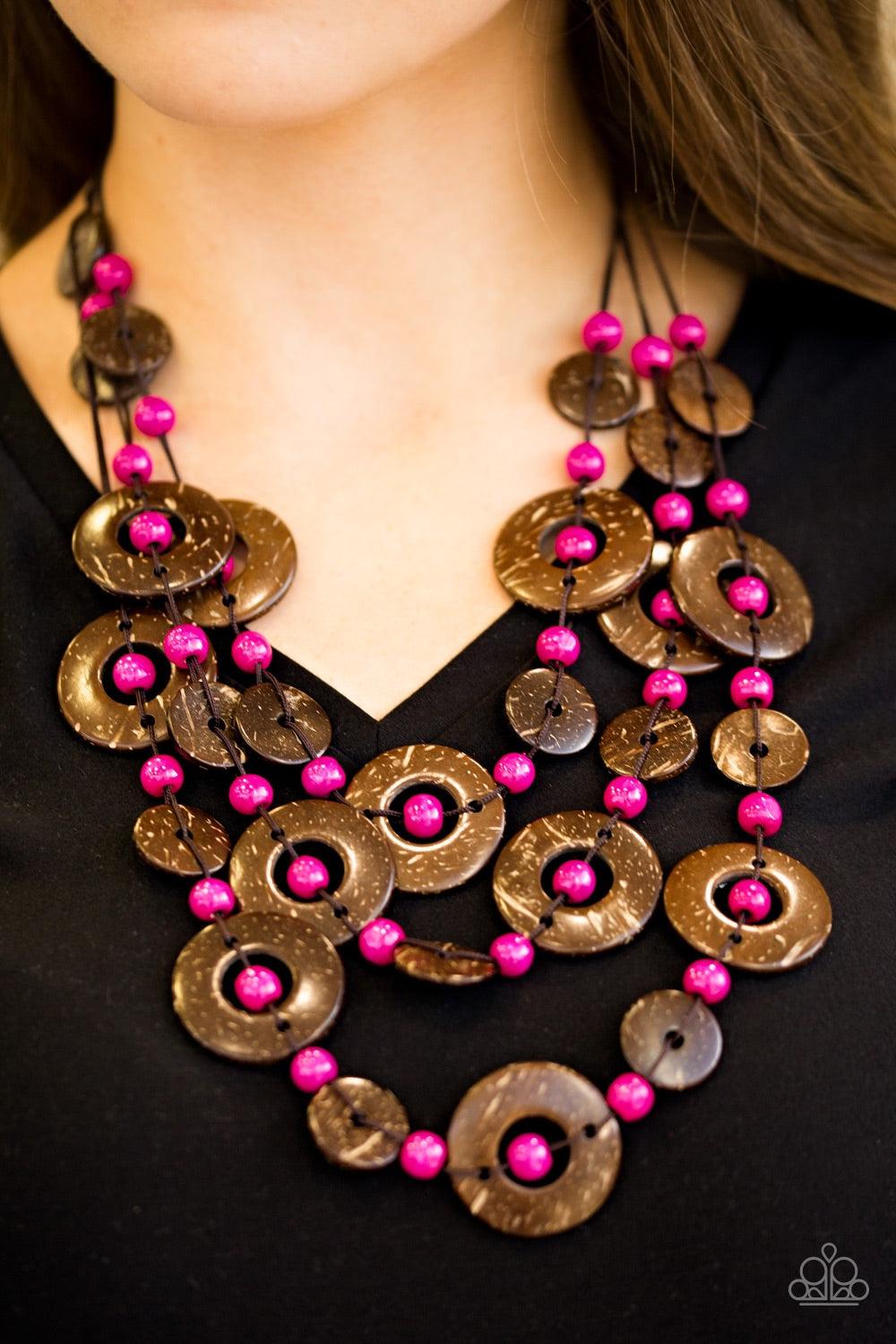Paparazzi Accessories Bahama Bungalow - Pink Brushed in a distressed finish, wooden discs link into three summery rows below the collar. Round pink beads are knotted between the wooden accents, adding colorful accents to the seasonal palette. Features a b