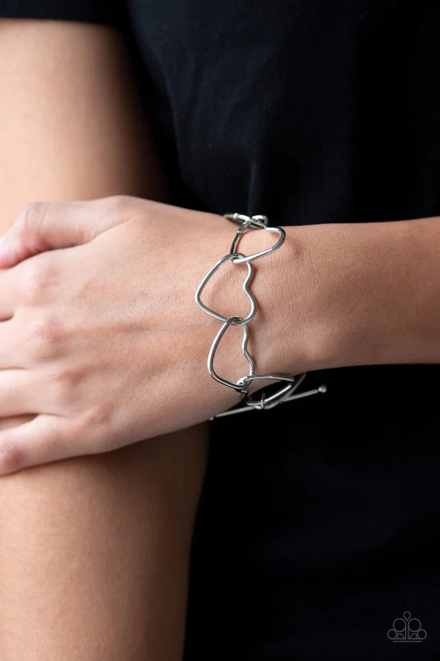 Paparazzi Accessories Take Heart - Silver Airy silver heart silhouettes connect around the wrist for a flirtatious look. Features a toggle closure. Sold as one individual bracelet. Jewelry