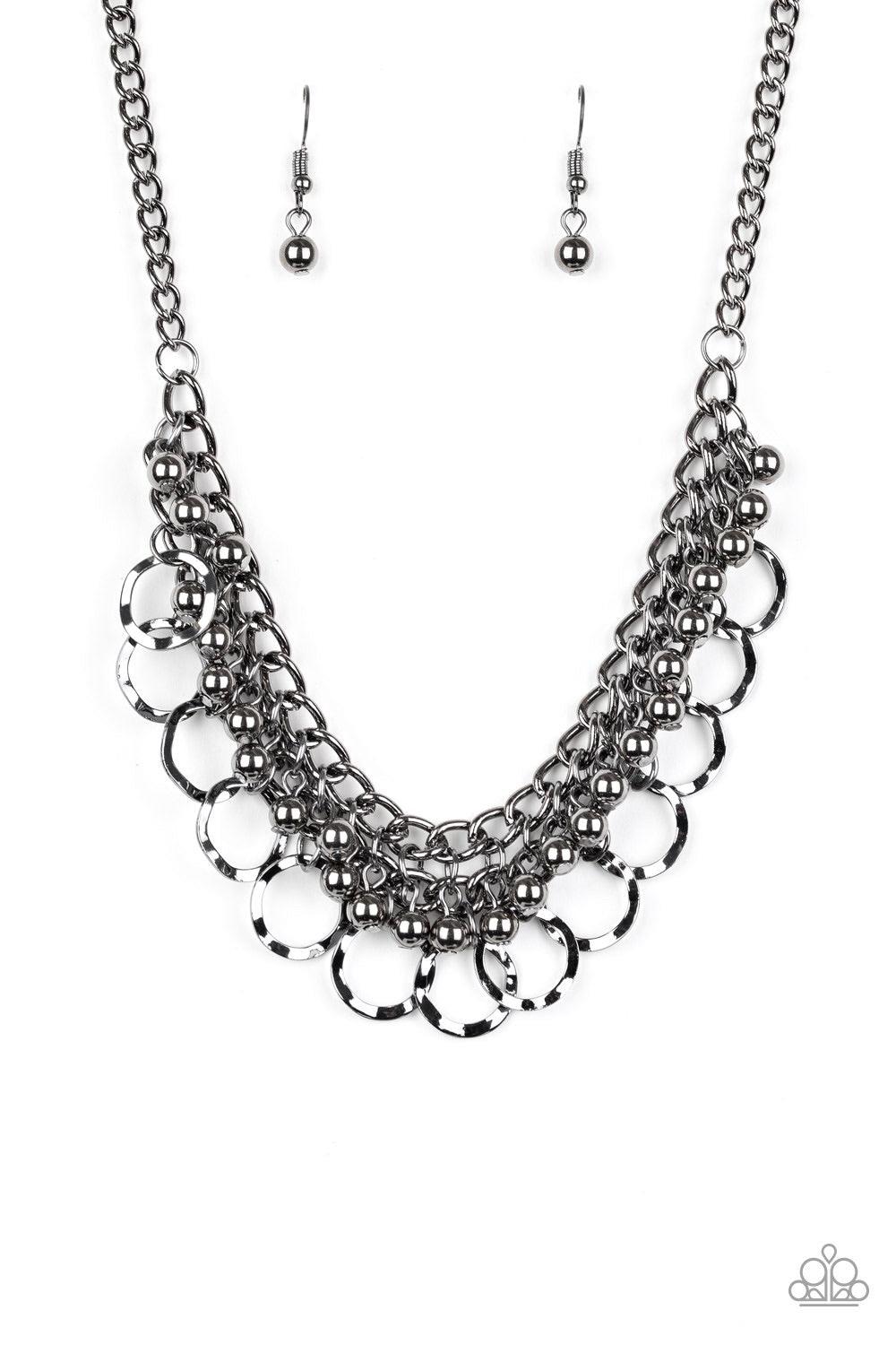 Paparazzi Accessories Ring Leader Radiance - Black Rows of shiny gunmetal beads and hammered gunmetal rings swing from the bottom of interlocking gunmetal chains, creating a bold fringe below the collar. Features an adjustable clasp closure. Jewelry