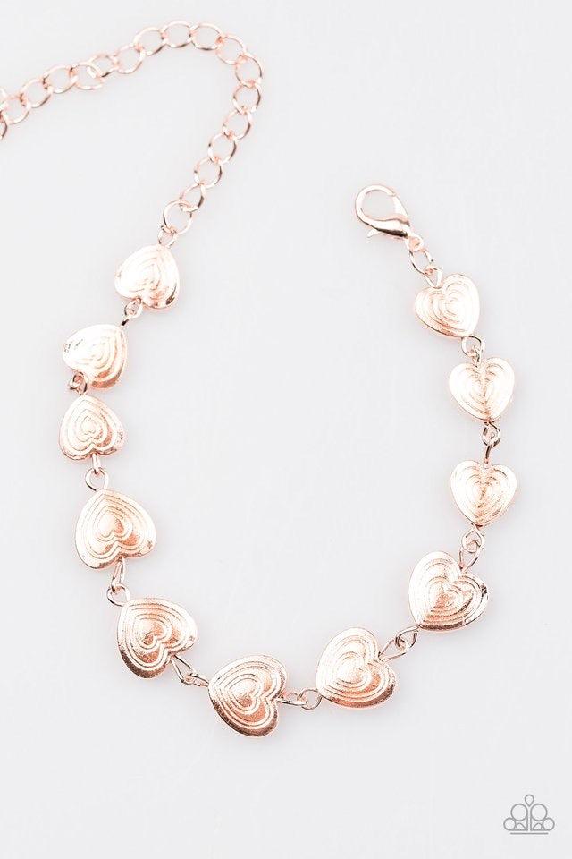Paparazzi Accessories No Heart Feelings - Rose Gold Engraved in rippling heart patterns, glistening rose gold hearts link across the wrist in a casual fashion. Features an adjustable clasp closure. Jewelry