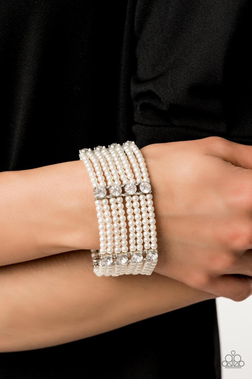 Paparazzi Accessories Get In Line - White Held together by stacked white rhinestone encrusted frames, a collection of dainty white pearls are threaded along stretchy bands around the wrist for a timeless twist. Jewelry