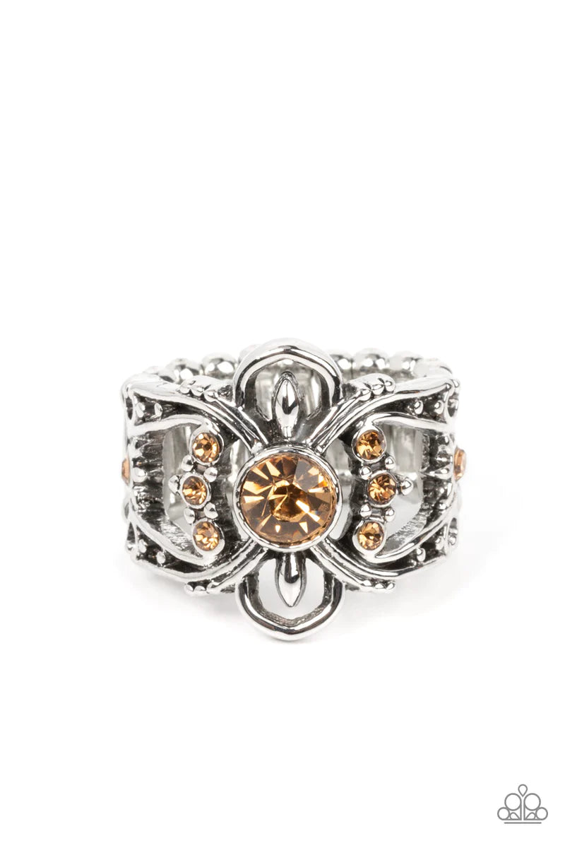 Paparazzi Accessories We Wear Crowns Here - Brown A solitaire golden topaz rhinestone is flanked by stacked rows of dainty golden topaz rhinestones inside swooping silver bars dotted in antiqued silver studs, resulting in a refined sparkle atop the finger
