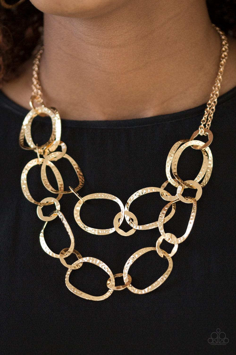 Paparazzi Accessories Circus Chic - Gold Featuring hexagonal centers, dainty gold rings link together two rows of hammered gold frames. The layered rows drape just below the collar for a refined look. Features an adjustable clasp closure. Sold as one indi