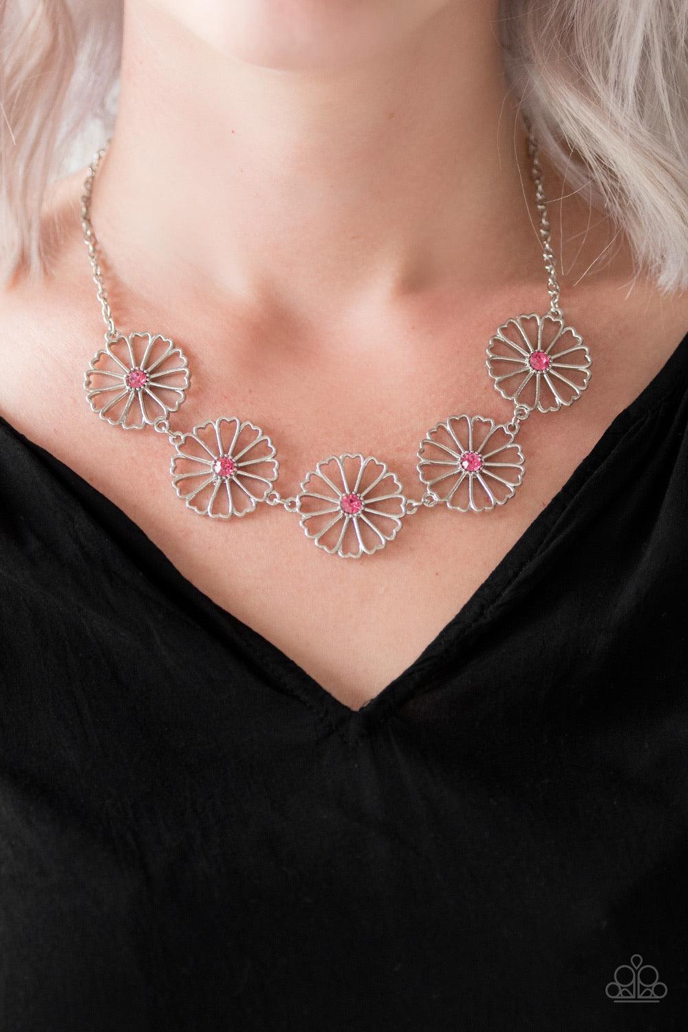 Paparazzi Accessories Daffodil Gardens - Pink Stenciled silver floral charms link below the collar. Glittery pink rhinestones dot the floral centers, adding a whimsical finish to the airy palette. Features an adjustable clasp closure. Sold as one individu