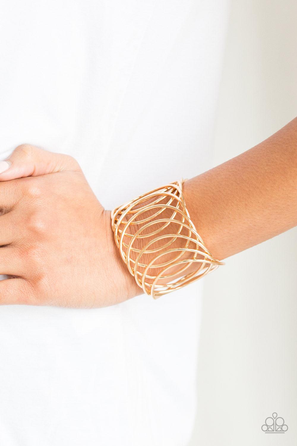 Paparazzi Accessories Dizzyingly Diva - Gold Overlapping gold circular frames coalesce into a dizzying cuff for a classic look. Jewelry