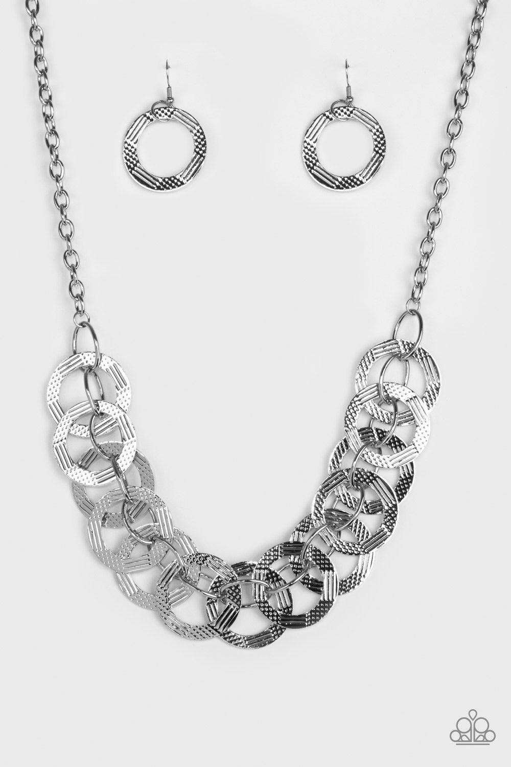 Paparazzi Accessories The Main Contender - Silver Etched and hammered in linear and diamond-cut shimmer, glistening silver circles interlock into a bold industrial chain below the collar. Features an adjustable clasp closure Jewelry