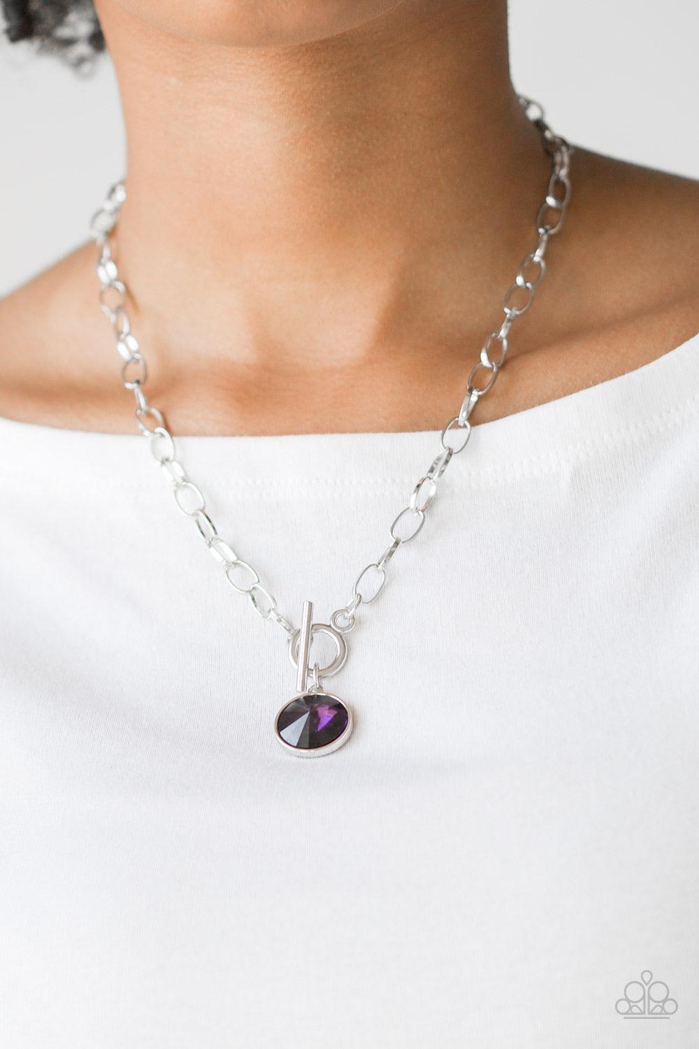 Paparazzi Accessories She Sparkles On - Purple A dramatic purple gem swings from the bottom of a shiny silver chain, creating a blinding pendant below the collar. Features a toggle closure. Jewelry