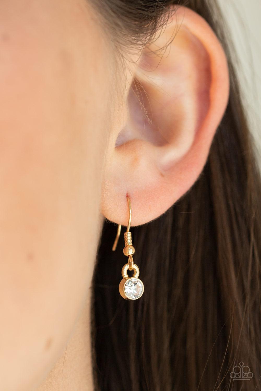 Paparazzi Accessories Not A HEIR Out Of Place - Gold Encrusted in blinding white rhinestones, a sparkling gold ring swings from the bottom of a lengthened gold box chain. Flattened gold chains stream from the bottom of the glittery pendant for a regal fin