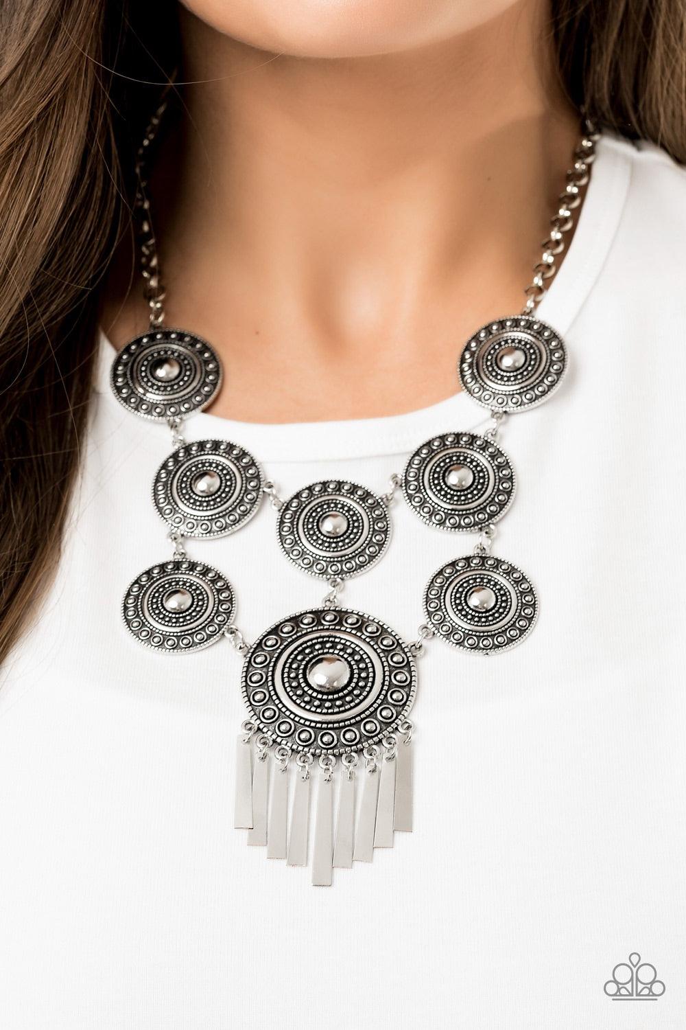 Paparazzi Accessories Modern Medalist - Silver Studded in tactile circular patterns, a collection of antiqued silver disc-like frames connects into a stacked tribal pendant. A larger silver disc is suspended from the bottom, giving way to a fringe of flar