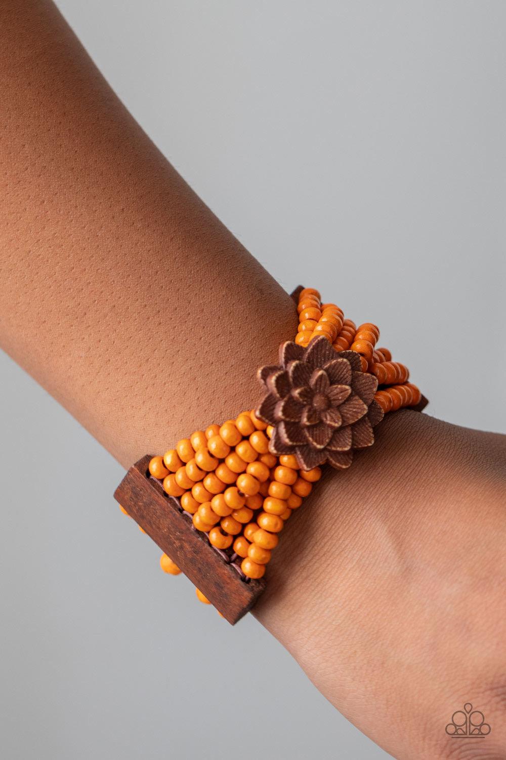 Paparazzi Accessories Tropical Sanctuary ~Orange Held together by oversized rectangular fittings and wooden floral frames, strands of refreshing orange wooden beads are threaded along stretchy bands that weave around the wrist for a colorful island inspir