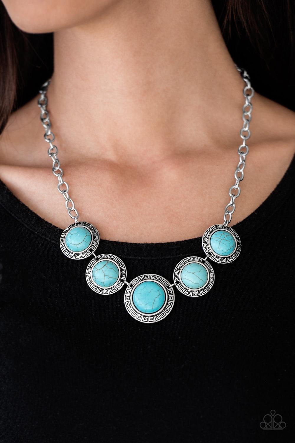 Paparazzi Accessories Mountain Roamer - Blue Chiseled into tranquil circles, smooth turquoise stones are pressed into ornate silver frames and linked below the collar for a tribal inspired look. Features an adjustable clasp closure. Sold as one individual