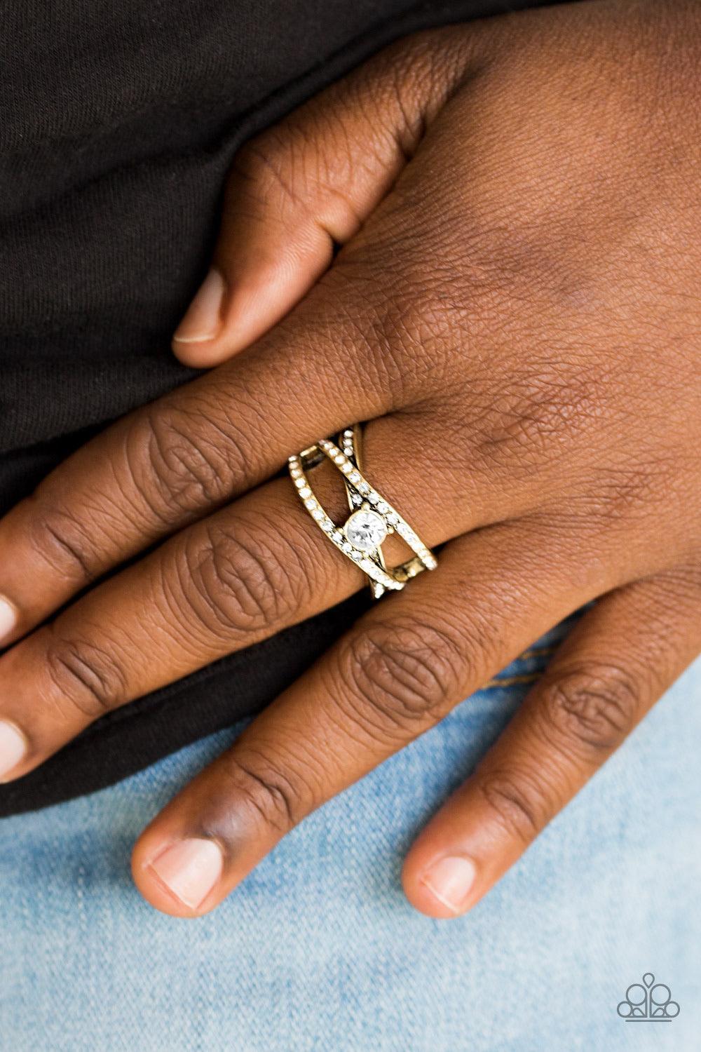 Paparazzi Accessories Prepare To Be Dazzled! * Brass Encrusted in glittery white rhinestones, shiny brass bars crisscross across the finger. A sparkling white rhinestone adorns the center of the bands, creating a dazzling centerpiece. Features a stretchy