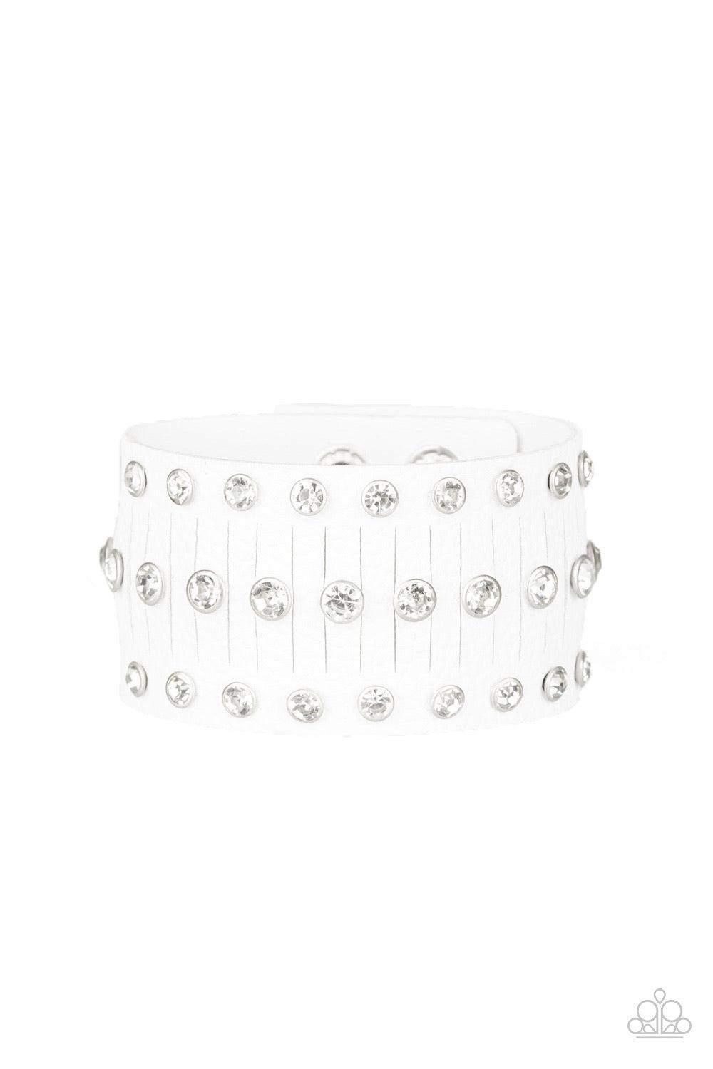 Paparazzi Accessories Now Taking The Stage - White Pressed into sleek silver frames, glittery white rhinestones are studded across a thick white leather band featuring a center lined with slits for a sassy finish. Features an adjustable snap closure. Jewe
