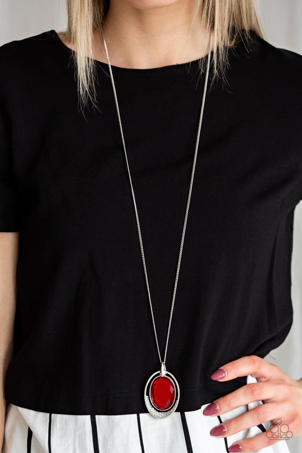 Paparazzi Accessories Metro Must Have - Red An oversized red gem swings from the top of an airy silver frame, creating a refined double pendant at the bottom of a lengthened silver chain. As if dipped in glitter, the bottom of the silver frame is encruste