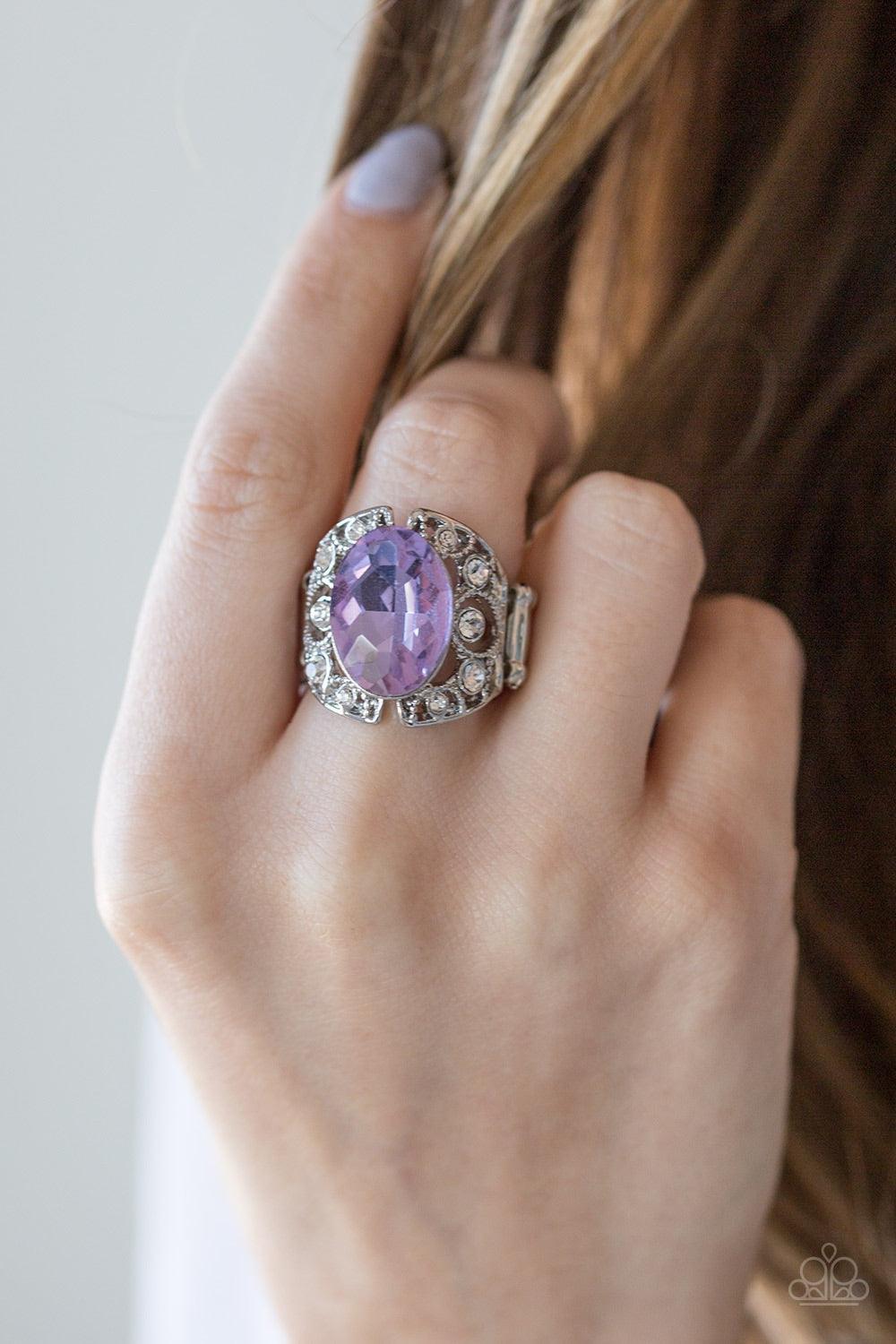 Paparazzi Accessories Queen of Hustle ~Purple A glassy purple gem sits atop a frilly filigree backdrop radiating with glassy white rhinestones for a regal look. Features a stretchy band for a flexible fit.