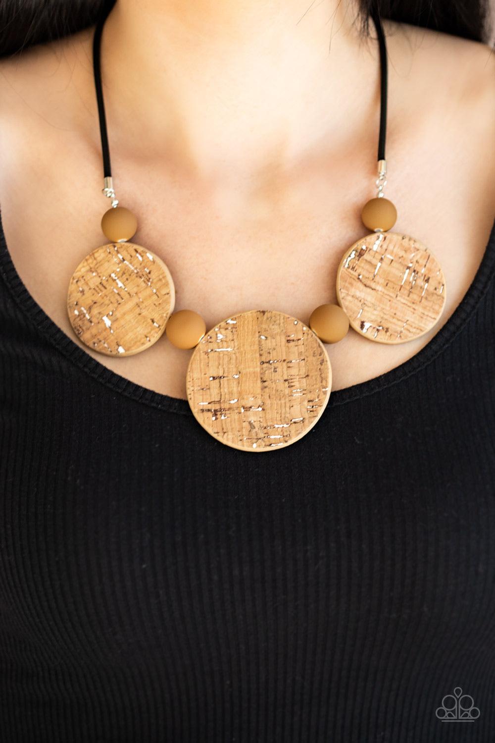 Paparazzi Accessories Pop The Cork - White Featuring white accents, cork-like frames and brown matte beads are threaded along an invisible wire below the collar for a statement-making look. Features an adjustable clasp closure. Sold as one individual neck