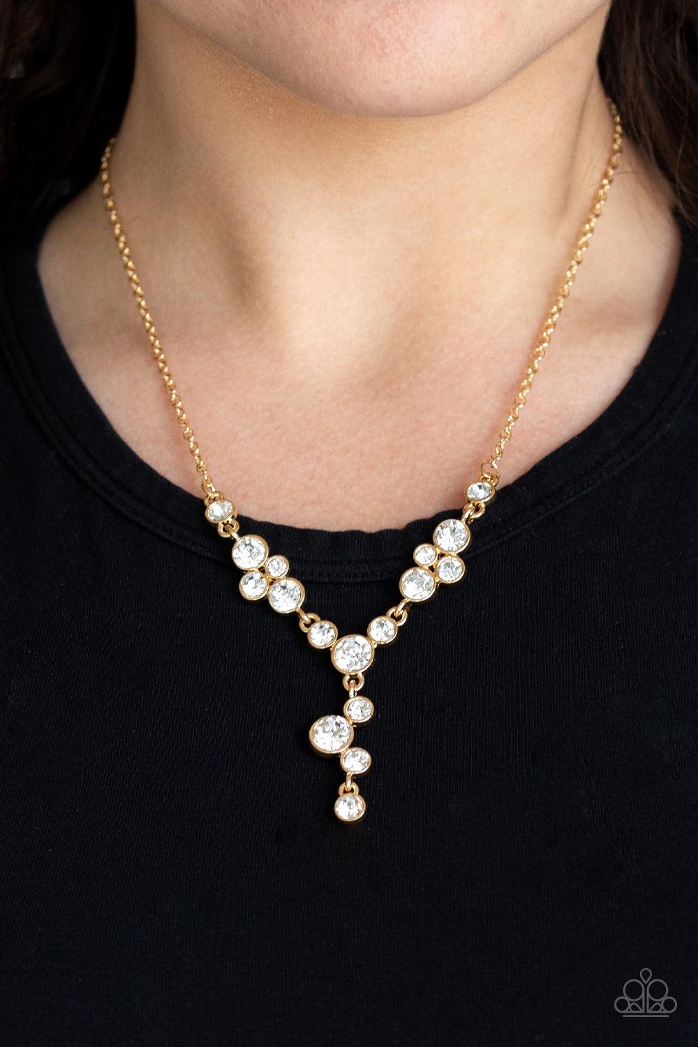 Paparazzi Accessories Five-Star Starlet - Gold Encased in sleek gold frames, a collection of glittery white rhinestones coalesce into dazzling frames below the collar. Matching rhinestones trickle from the center, creating a glamorous extended pendant. Fe