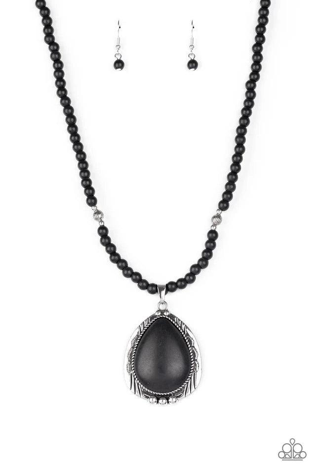 Paparazzi Accessories Evolution - Black An oversized black stone teardrop is pressed into the center of an ornate silver frame that is studded and stamped in tribal inspired patterns. The rustic pendant glides along an earthy strand of black stone and ant