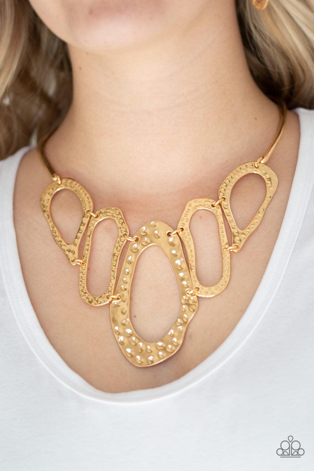 Paparazzi Accessories Prime Prowess - Gold Attached to two bent gold bars, delicately hammered asymmetrical gold hoops link below the collar for an edgy statement making look. Features an adjustable clasp closure. Sold as one individual necklace. Includes