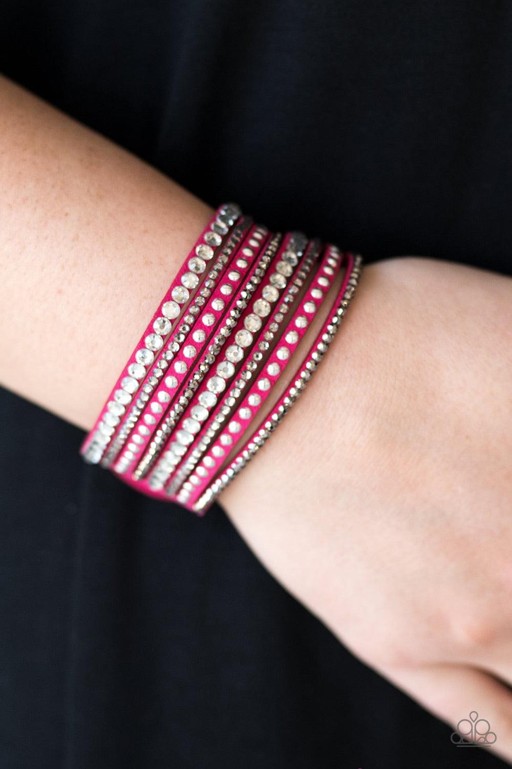 Paparazzi Accessories Guitars And Glitter - Pink A mishmash of smoky, white, and glittery hematite rhinestones are sprinkled along skinny strands of pink suede. Rows of shiny silver studs are added to the rock star palette for a shimmery metallic finish.