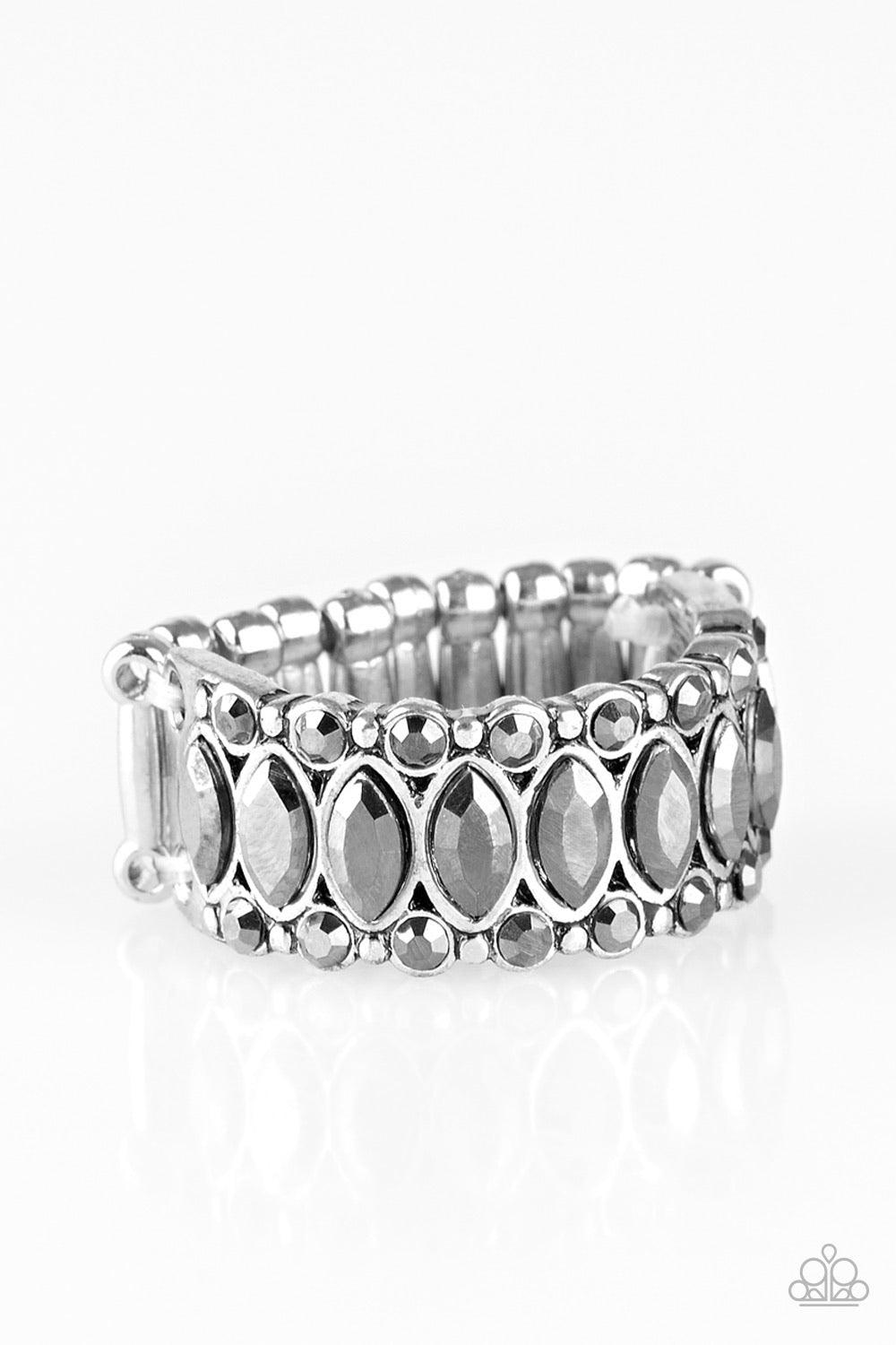 Paparazzi Accessories Radical Riches - Silver Featuring regal marquise style cuts, glittery hematite rhinestones are encrusted down the center of a silver band radiating with glassy hematite rhinestones for an edgy look. Features a stretchy band for a fle