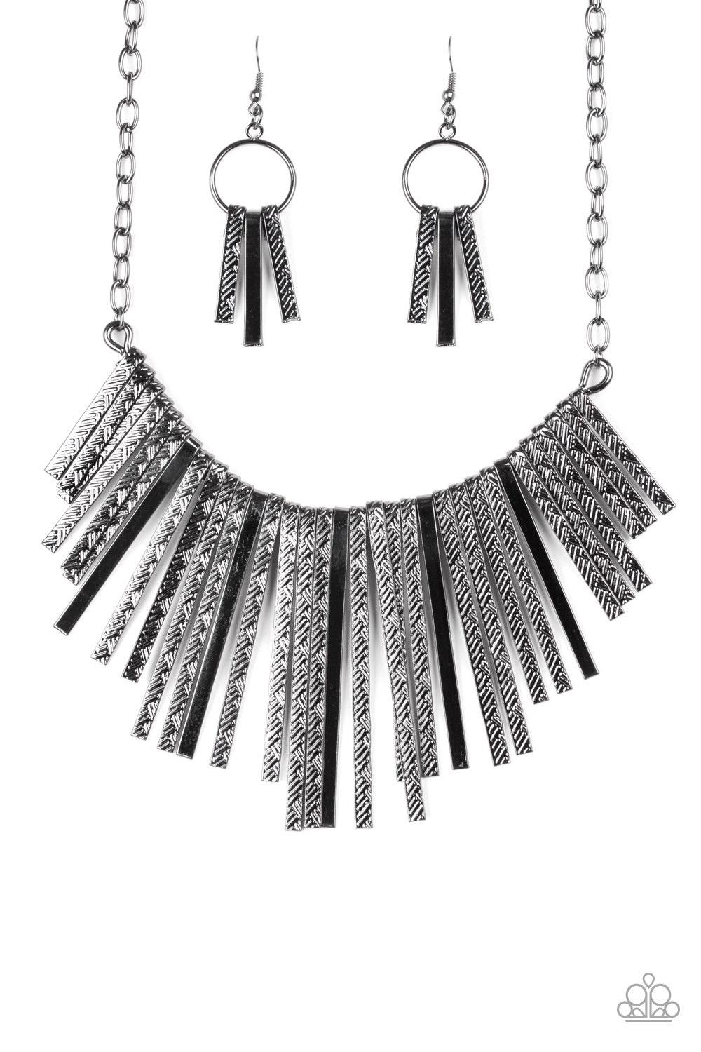 Paparazzi Accessories Welcome To The Pack - Black Embossed in edgy linear patterns, flat gunmetal rods alternate with plain gunmetal rods below the collar, creating a fiercely tapered fringe. Features an adjustable clasp closure. Jewelry