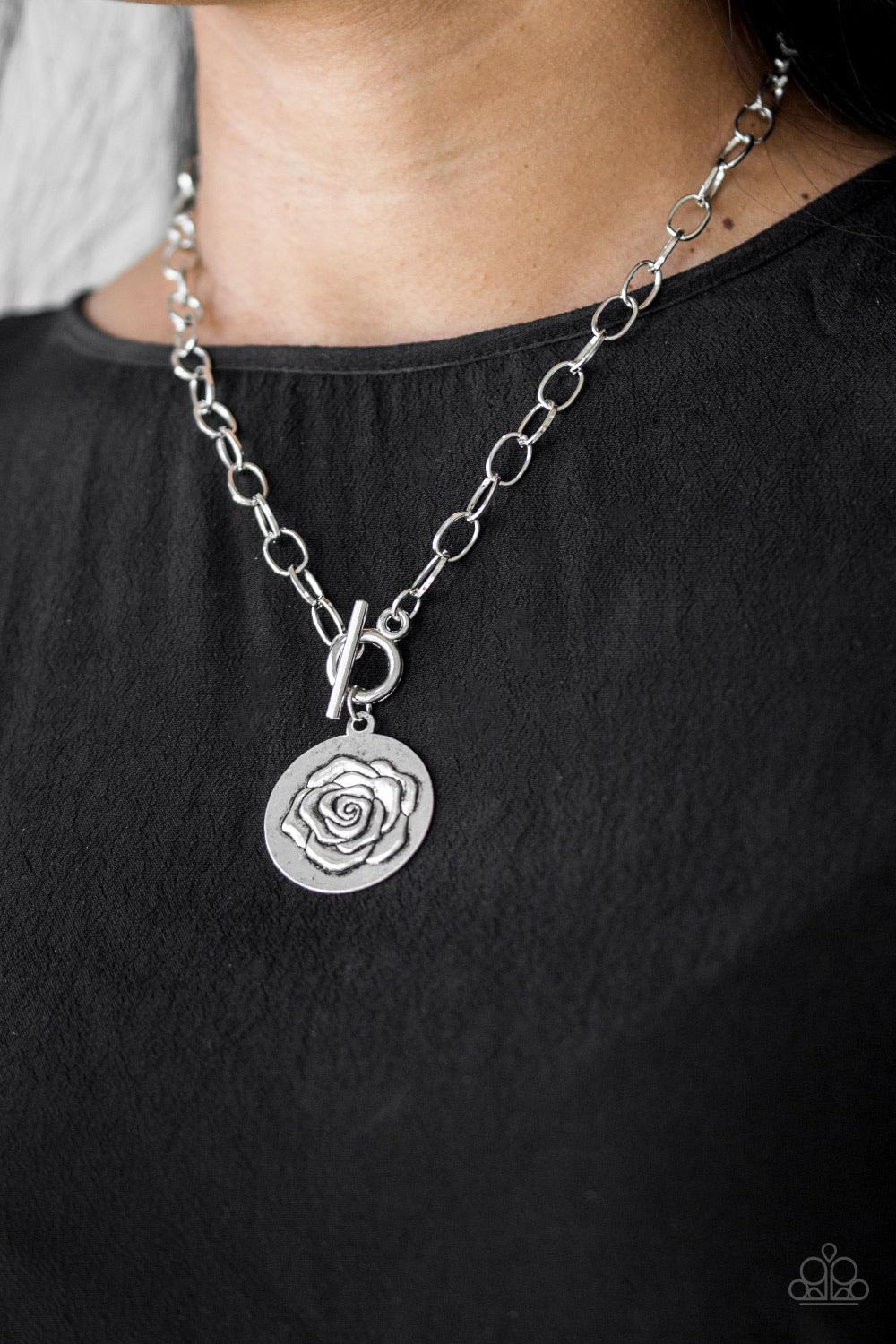 Paparazzi Accessories Beautifully Belle - Silver Embossed in a whimsical rosebud pattern, a shimmery silver frame swings below the collar for a casual look. Features a toggle closure. Sold as one individual necklace. Includes one pair of matching earrings
