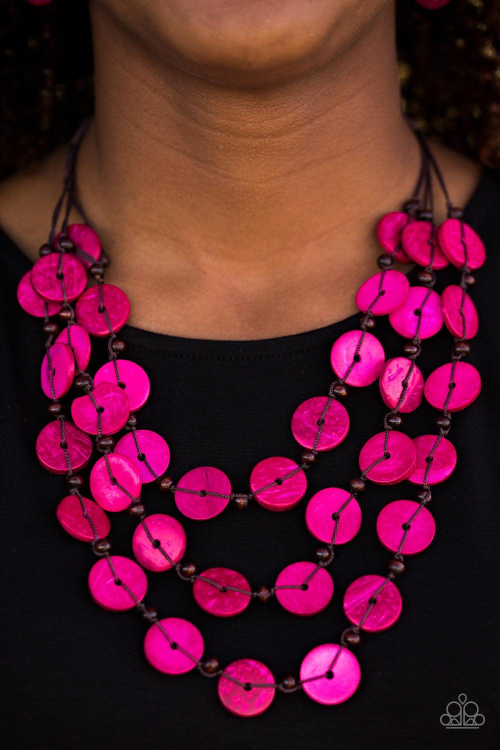 Paparazzi Accessories Tiki Tango - Pink Tinted in pink finishes, shiny wooden discs trickle along shiny brown cording, creating three colorful layers below the collar. Features a button-loop closure. Sold as one individual necklace. Includes one pair of m