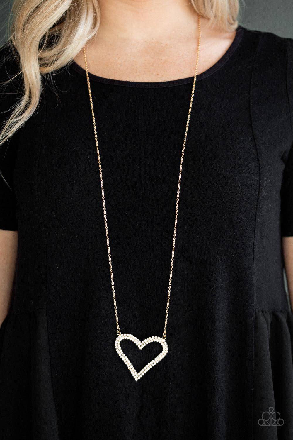 Paparazzi Accessories Pull Some HEART-strings - Gold Two rows of glittery white rhinestones stack into a sparkling heart pendant at the bottom of a lengthened gold chain for a heart-stopping look. Features an adjustable clasp closure. Jewelry