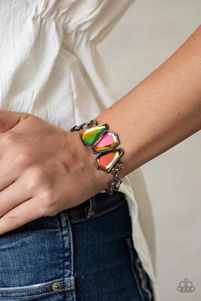 Paparazzi Accessories Raw Radiance - Multi Attached to a shiny gunmetal chain, a trio of sparkly oil spill gem-shaped rhinestones join into a glamorous centerpiece atop the wrist. Features an adjustable clasp closure. Sold as one individual bracelet. Jewe