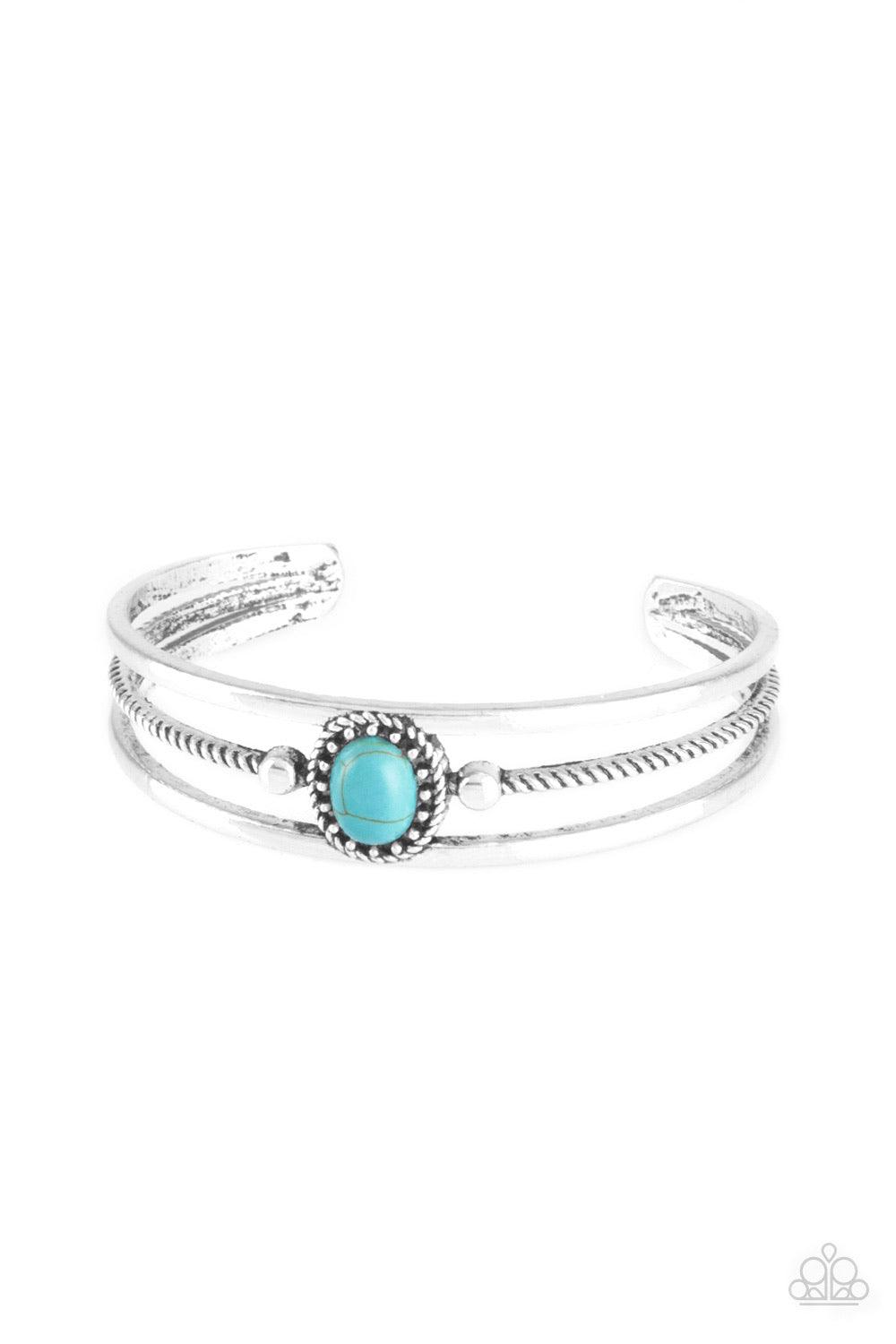 Paparazzi Accessories Borderline Borderland - Blue Serrated and smooth silver bars arc across the wrist, coalescing into an airy cuff. Infused with a studded frame, a refreshing turquoise stone is pressed into the center of the cuff for a seasonal look. S
