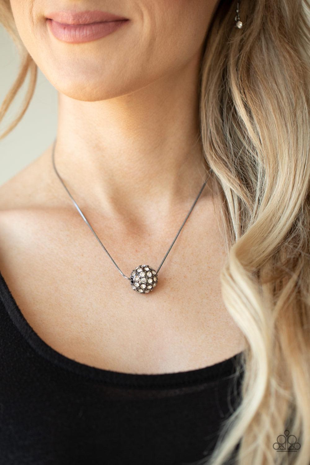 Paparazzi Accessories Come out of Your BOMBSHELL - Black Bedazzled in glittery white rhinestones, a dramatic gunmetal bead slides along a sleek gunmetal chain below the collar for a statement-making look. Features an adjustable clasp closure. Sold as one