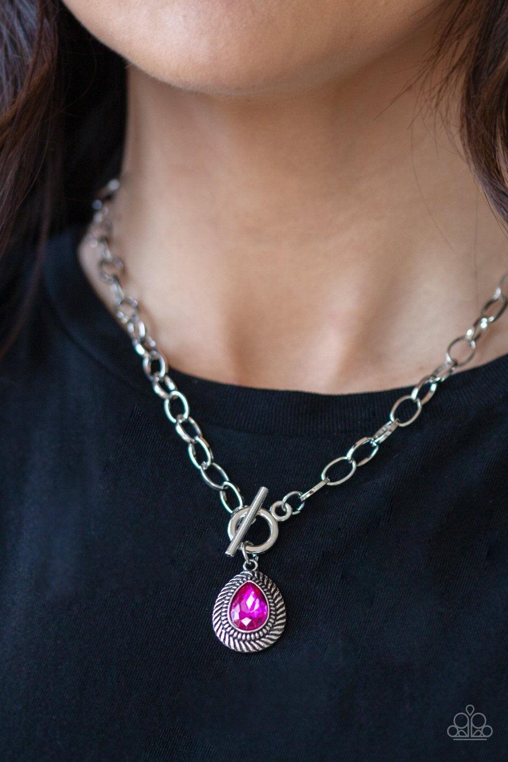 Paparazzi Accessories Sheen Queen - Pink A faceted pink teardrop gem is pressed into a textured silver frame. The glamorous pendant swings from a shimmery silver hoop below the collar for statement-making fashion. Features a toggle closure. Jewelry