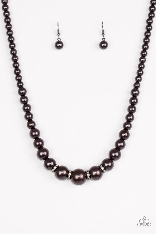 Paparazzi Accessories Party Pearls - Black Gradually increasing in size, pearly gunmetal beads trickle below the collar for a classic look. Encrusted in dazzling white rhinestones, glittery rings are sprinkled between the pearls for a timeless finish. Fea
