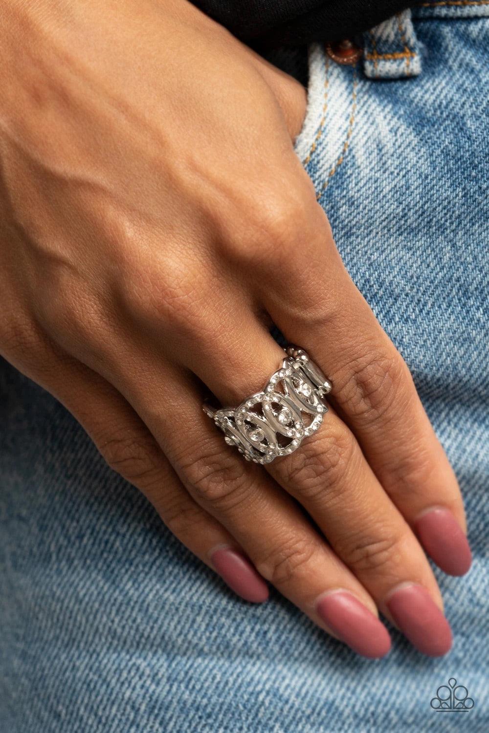 Paparazzi Accessories OVAL-Ruled - White Delicately overlapping across the finger, the tops and bottoms of silver ovals are encrusted in dainty white rhinestones. A row of solitaire white rhinestones adorns the center, creating a regal centerpiece. Featur