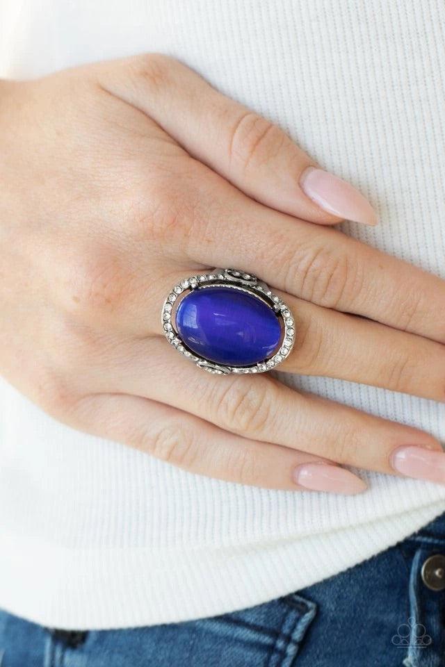Paparazzi Accessories Happily Ever Enchanted - Blue An oval blue cat's eye stone is nestled inside a ring of white rhinestones featuring dainty heart details, creating a charming centerpiece atop the finger. Features a stretchy band for a flexible fit. Je