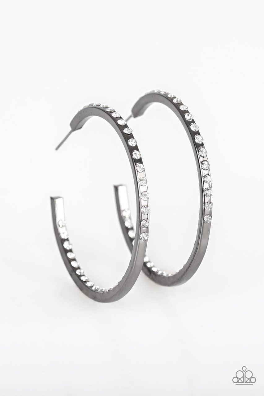 Paparazzi Accessories Comin’ Into Money - Black The front half and inner backside of a sleek gunmetal hoop is encrusted in glassy white rhinestones, easily catching and reflecting the light for an extra dash of shimmer. Earring attaches to a standard post