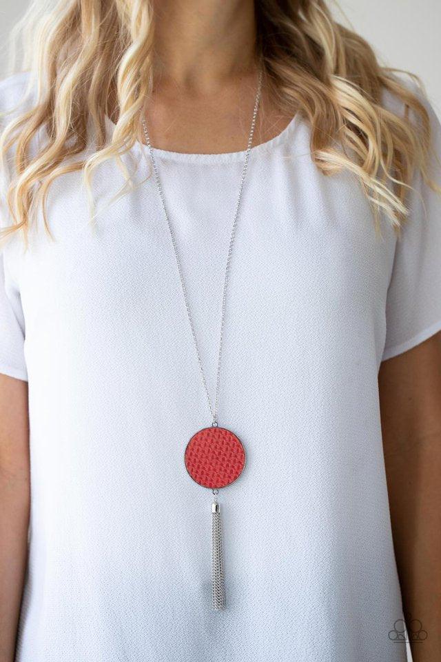 Paparazzi Accessories Wondrously Woven - Red Featuring a faux woven finish, a shiny piece of Fire Whirl leather is pressed into a studded circular frame at the bottom of a lengthened silver chain. Capped in a frame, a silver chain tassel streams out from